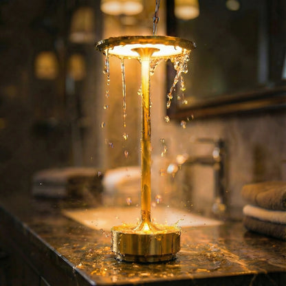 Lámpara de mesa inalámbrica recargable Eclara Ilumina dorada resistente al agua encendida sobre lavabo de mármol en baño de lujo